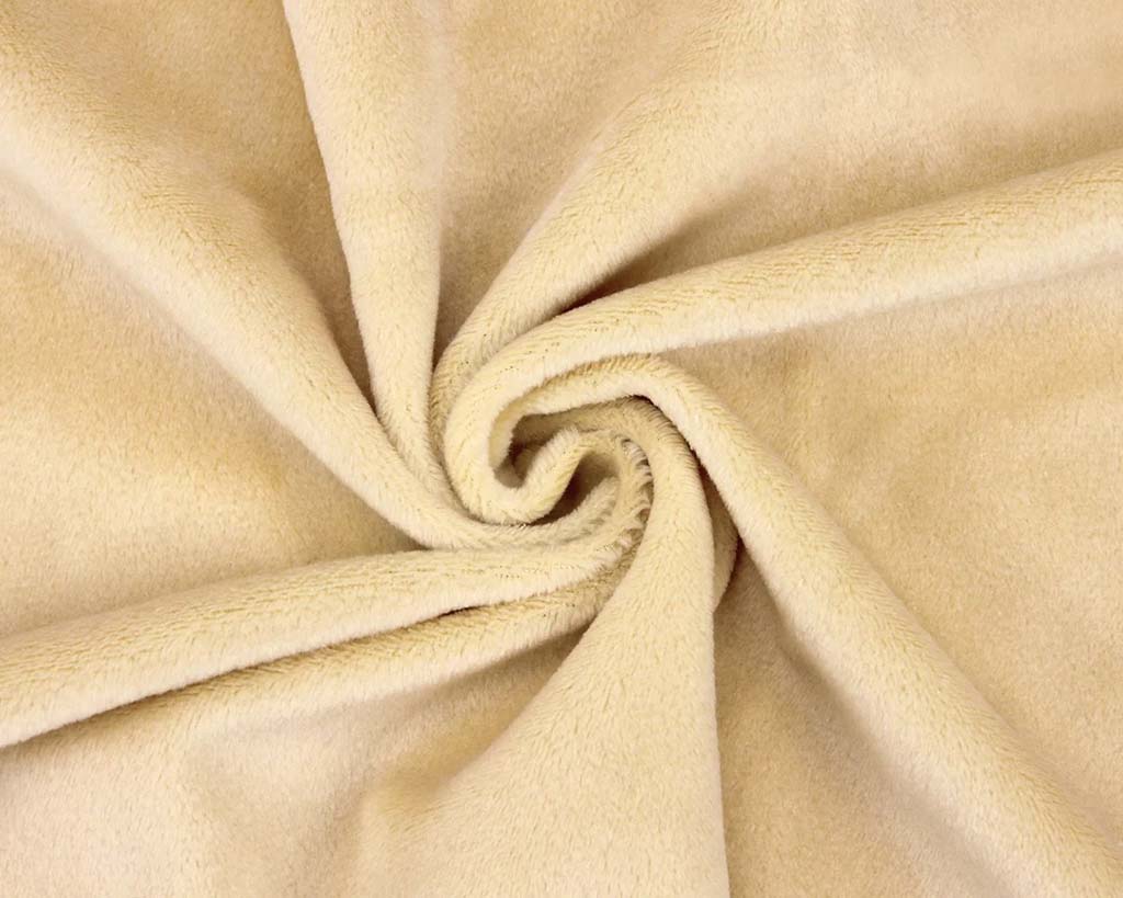 Close-up of soft beige plush fabric twisted in a spiral shape, showing its smooth, velvety texture commonly used for stuffed animals and plush toys.