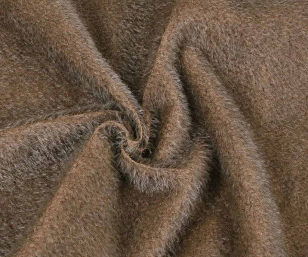 Close-up of brown long-pile plush fabric twisted in a spiral shape, showing its fluffy, soft texture commonly used for stuffed animals and plush toy manufacturing.