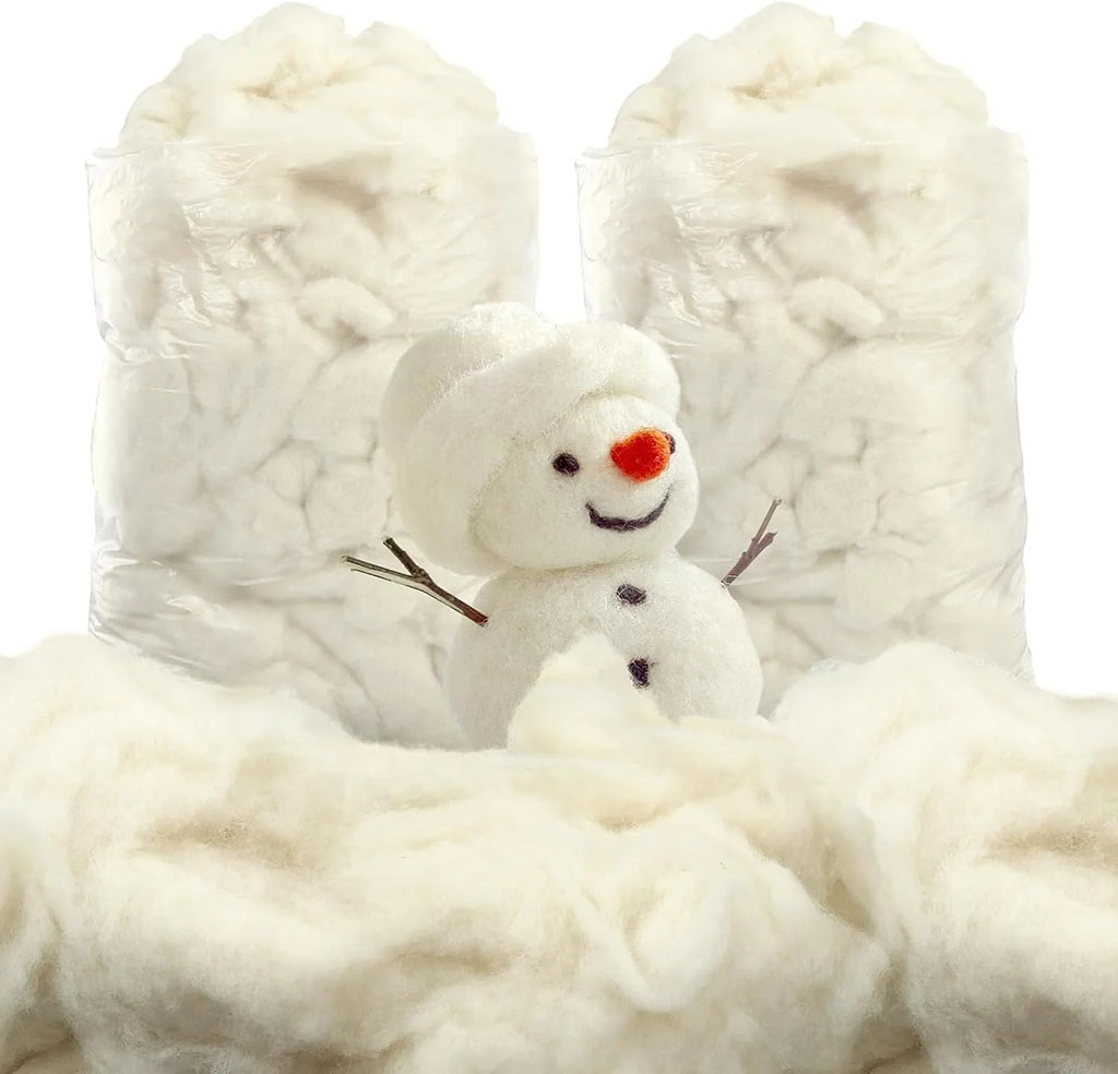 Soft white wool stuffing material with a small felt snowman decoration, used for filling handmade plush toys and crafts.