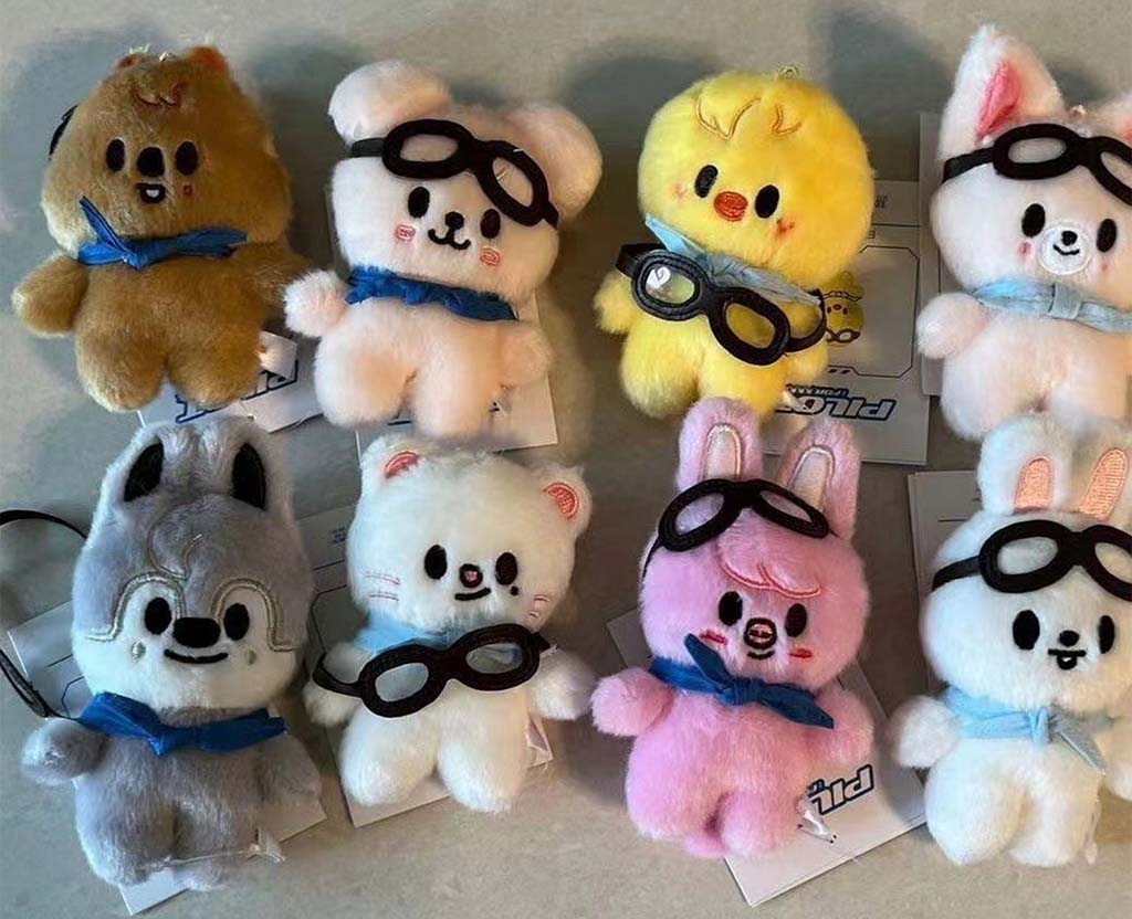 Set of eight cute plush animal keychains in various colors wearing blue scarves and black goggles.