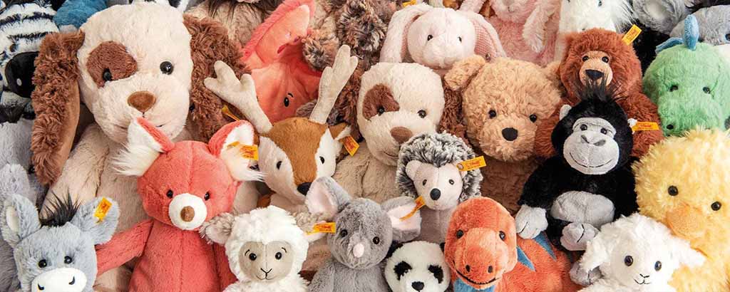 A large group of various plush stuffed animals arranged closely together, featuring different animals, colors, and textures