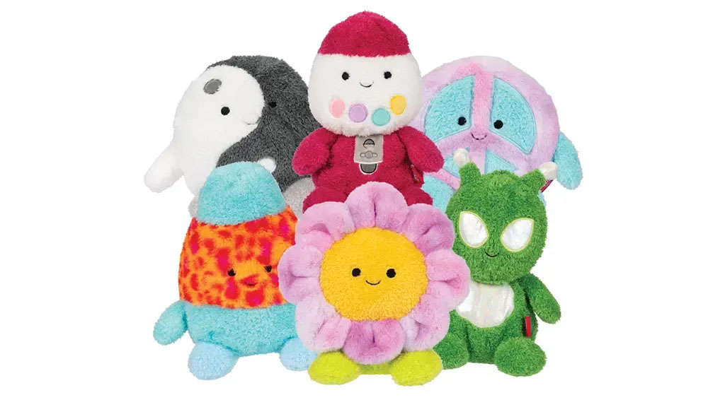 A group of colorful character plush toys, including a flower, alien, astronaut, peace sign, penguin, and lava-themed creature, displayed together on a white background.