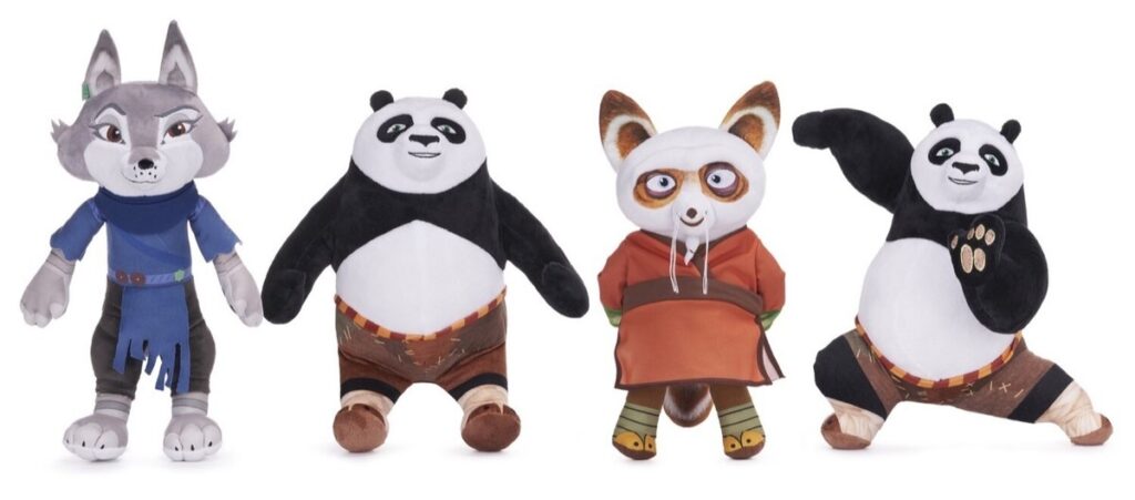 Four plush toys resembling animated Kung Fu Panda characters, including a gray wolf, two pandas in martial arts poses, and a red panda master wearing an orange robe, all standing upright against a white background.