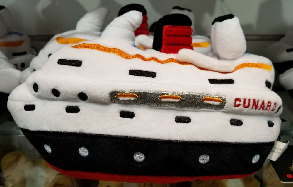 Soft plush cruise ship toy featuring embroidered windows, red smokestacks, and “CUNARD” branding on a white and black hull.