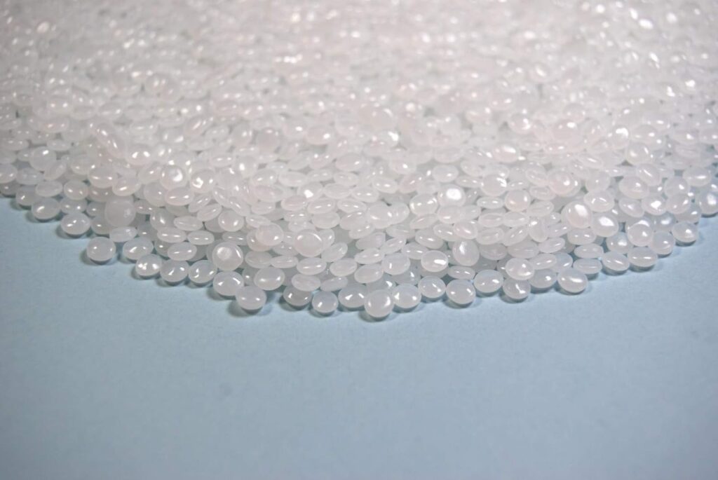 Close-up of smooth white polypropylene pellets commonly used as filling beads inside weighted stuffed animals and plush toys.