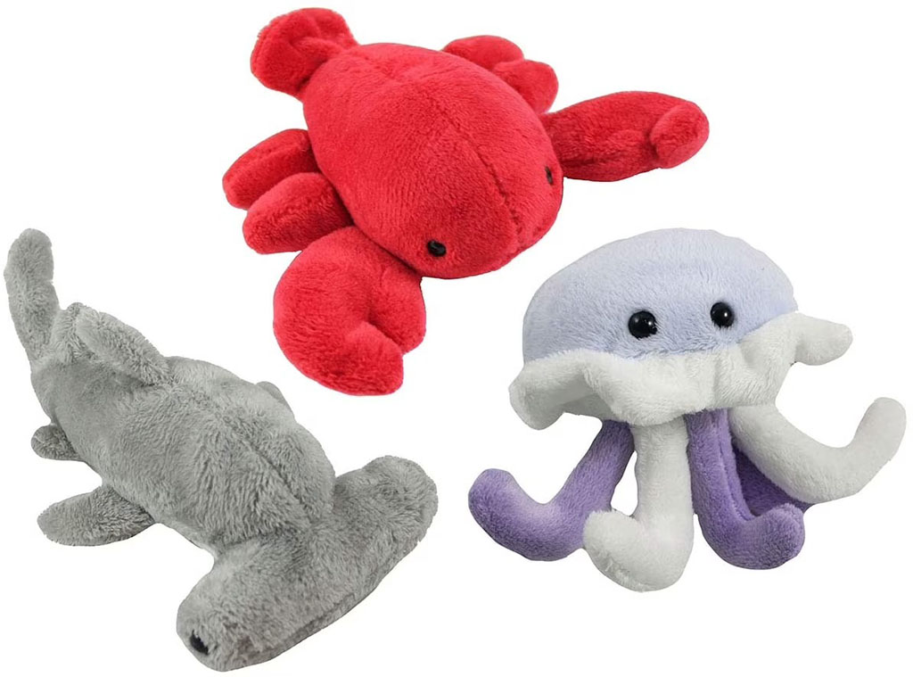 Three small plush ocean animals, including a red lobster, a gray hammerhead shark, and a light purple-and-white jellyfish with soft dangling tentacles, arranged on a white background.
