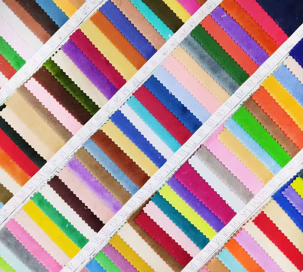 Assorted plush fabric swatches arranged in diagonal rows, displaying a wide range of vibrant colors and soft textures for plush toy design and production.