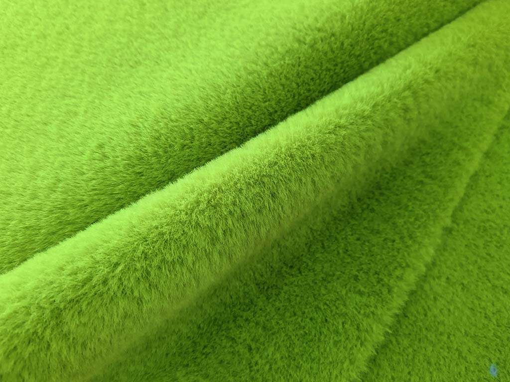Close-up of soft green faux rabbit fur fabric showing its smooth, dense, and short-pile texture used for high-quality plush toys and apparel.