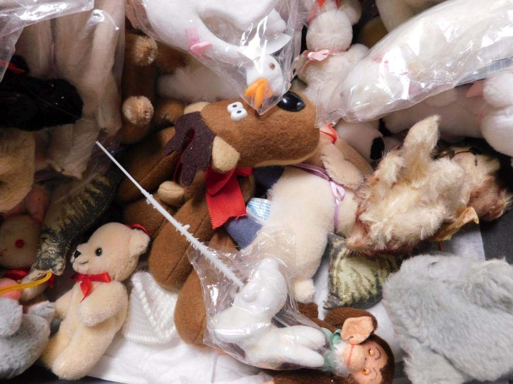 A large assortment of used plush toys piled together, including bears, reindeer, birds, and other stuffed animals, some in plastic bags and in various conditions, illustrating second-hand or recycled plush collection.