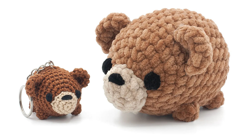 Two handmade crochet bear toys, one small brown bear keychain and one larger chunky-yarn bear plush, both in matching colors with cute round shapes.