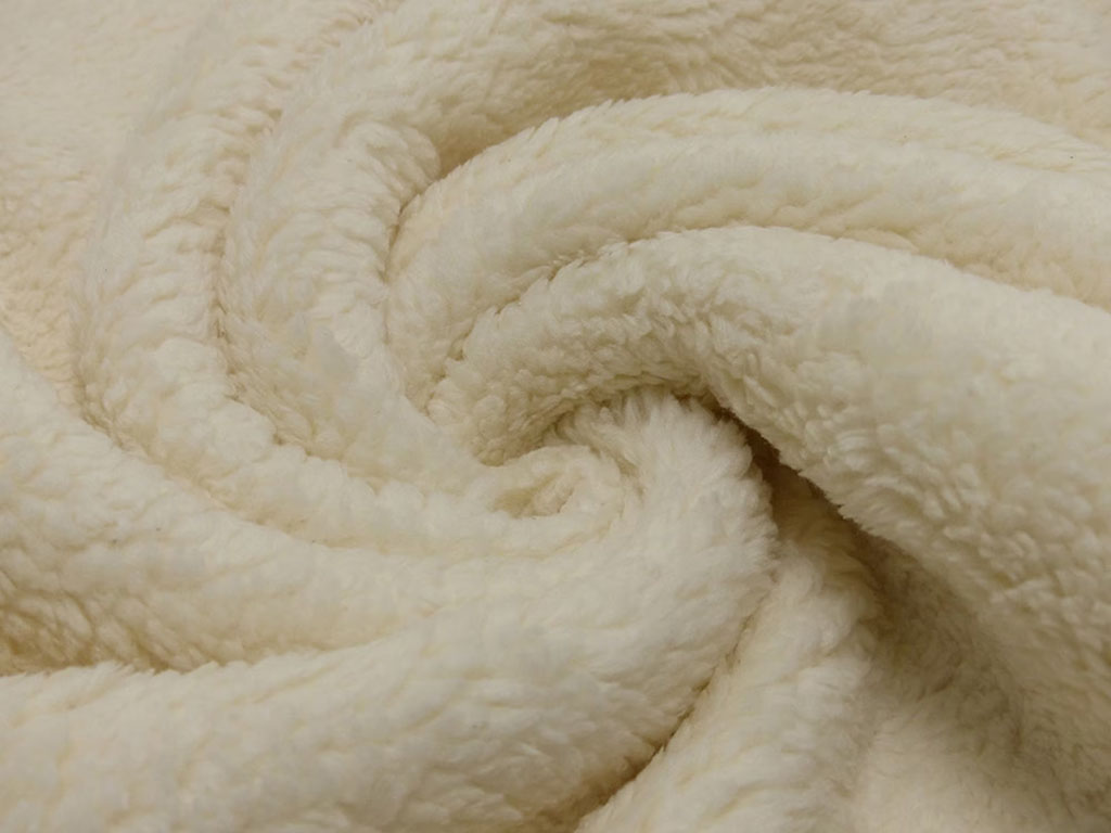 Close-up of soft cream sherpa plush fabric with thick, curly texture shown in folds, highlighting its warmth and suitability for stuffed animals and cozy textile projects.