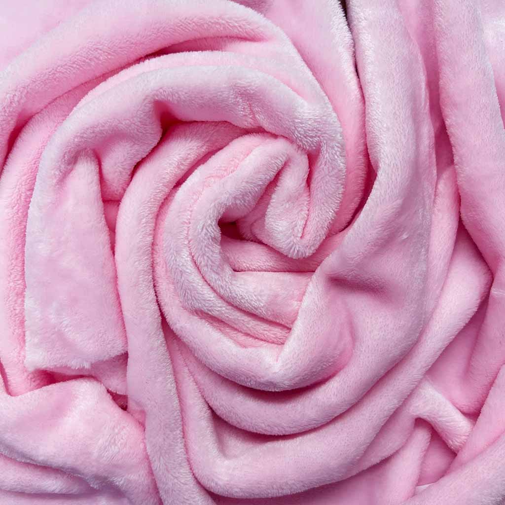 Soft pink plush fabric rolled into a swirl, showing its smooth and velvety texture.