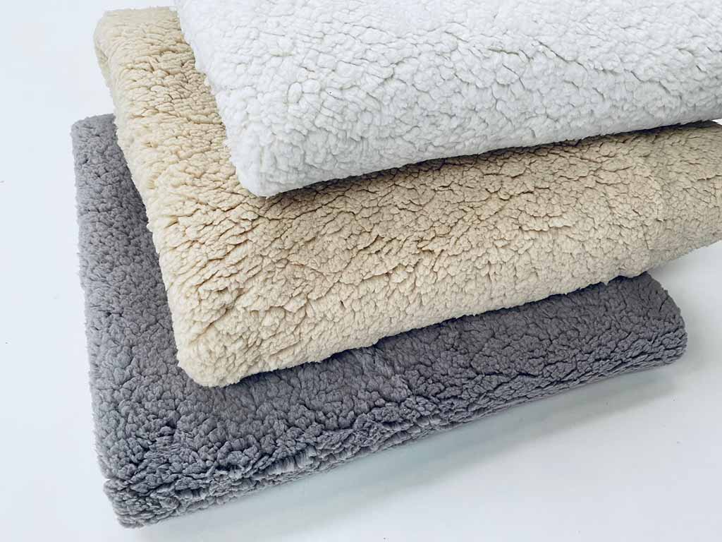 Stacked sherpa fleece fabrics in gray, beige, and white tones showing soft curly texture, ideal for plush toys, blankets, and cozy apparel lining.