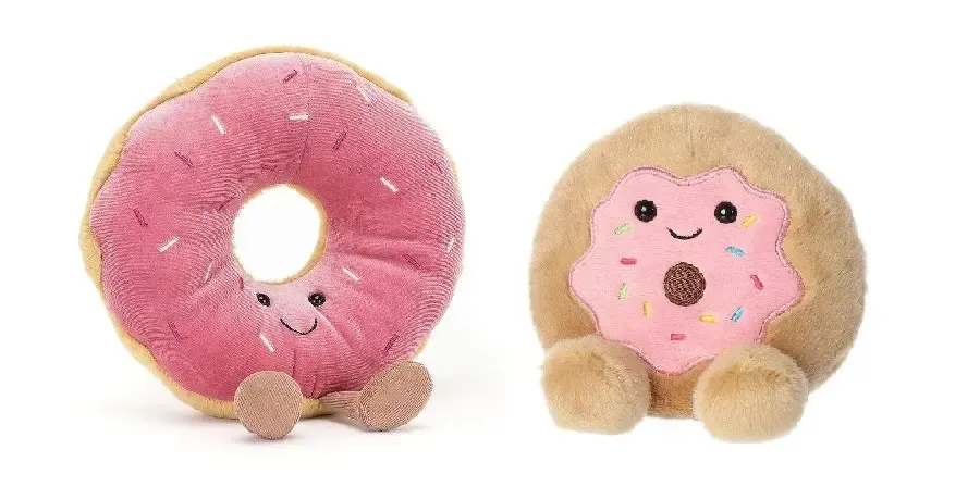 Two adorable donut-themed plush toys with pink frosting, smiling faces, and soft round feet displayed on a white background.