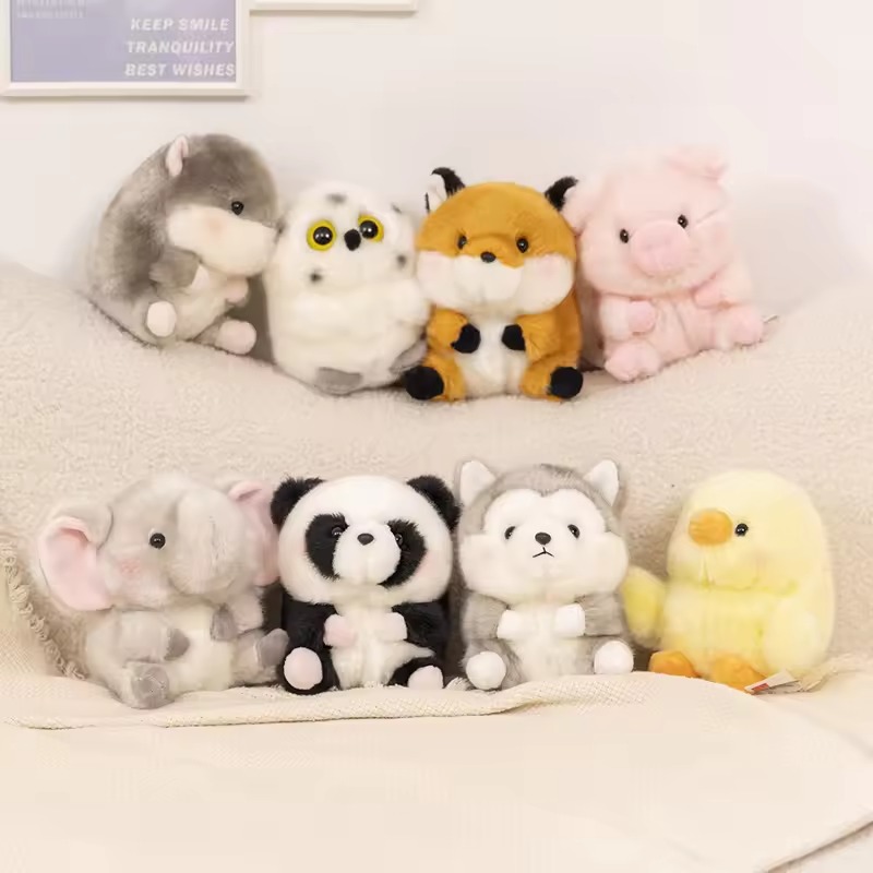 Eight small plush animals arranged on a sofa, including a husky, owl, fox, pig, elephant, panda, wolf, and chick, displayed in soft pastel and neutral colors