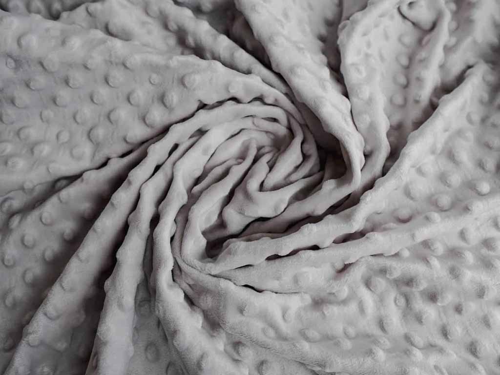 Soft gray minky fabric with raised dot texture, folded to show plush surface and bumpy pattern, commonly used for baby blankets and plush toys.