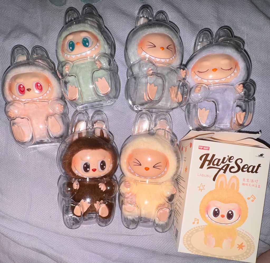 Collection of Labubu ‘Have a Seat’ blind box figures displayed in clear plastic cases, showing multiple pastel-colored characters with different facial expressions alongside the original product box.