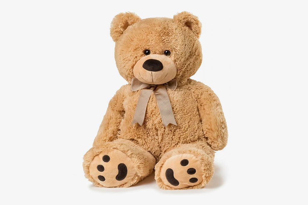 A classic brown plush teddy bear sitting upright with soft fur, stitched facial features, and a ribbon bow, designed for children, gifting, nursery decor, and comfort-focused play.