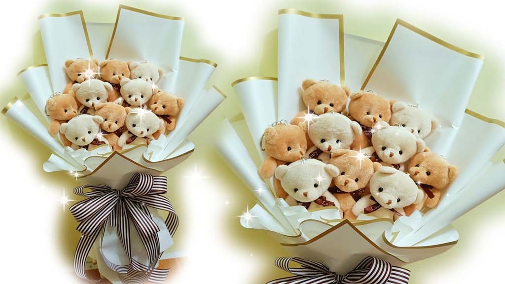 Bouquet made of multiple small plush teddy bears arranged in white and gold wrapping paper with a striped ribbon at the base.
