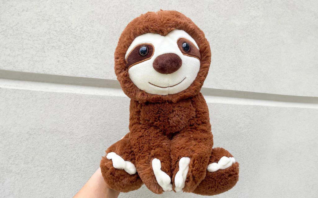 A soft brown sloth plush toy with a smiling face and long limbs, designed with high-pile fabric and gentle stuffing, suitable for children, teens, and adults seeking a comforting, decorative, or gift-ready stuffed animal.