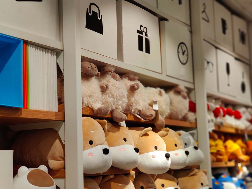Organized retail shelving filled with soft plush toys and stuffed animals, neatly displayed in a modern store environment, highlighting popular animal designs, uniform product presentation, and professional merchandising for gift shops, toy retailers, and wholesale plush suppliers.