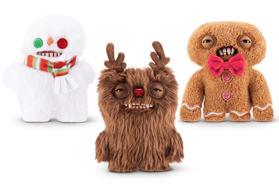 Three holiday-themed Fuggler plush toys, including a white snowman with button eyes and a striped scarf, a brown reindeer monster with antlers and a red nose, and a gingerbread-style Fuggler with a red bow tie and candy buttons, all featuring the signature toothy grins and quirky expressions.