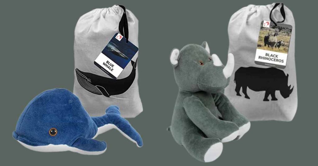 Plush blue whale and gray rhinoceros toys in branded bags.