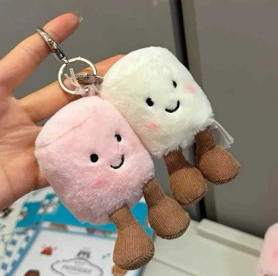 Cute pastel plush keychains with smiling faces and dangling legs.