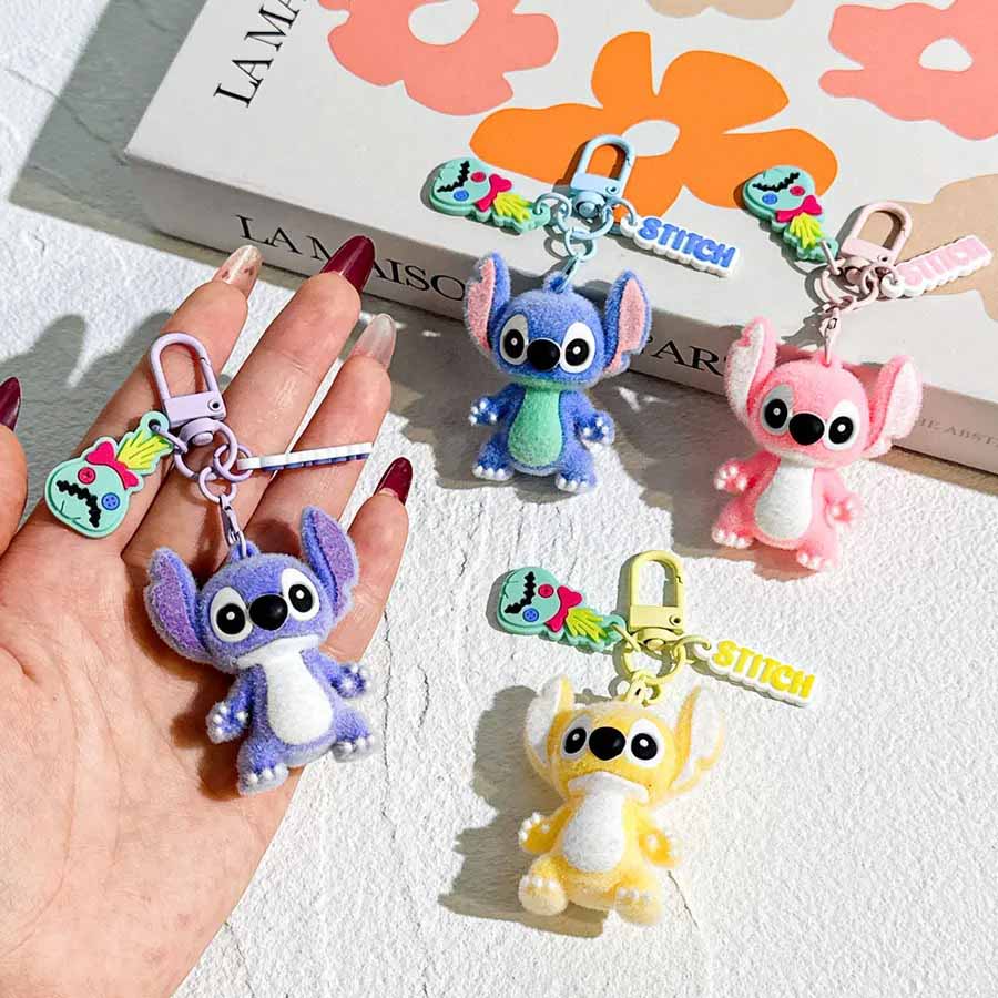 Colorful cartoon character plush keychains displayed on a hand and surface.