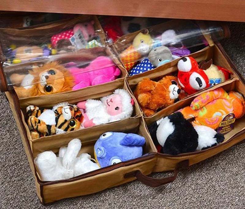 Under-bed zippered fabric organizer divided into compartments, neatly storing children’s stuffed animals and plush toys for space-saving bedroom storage.