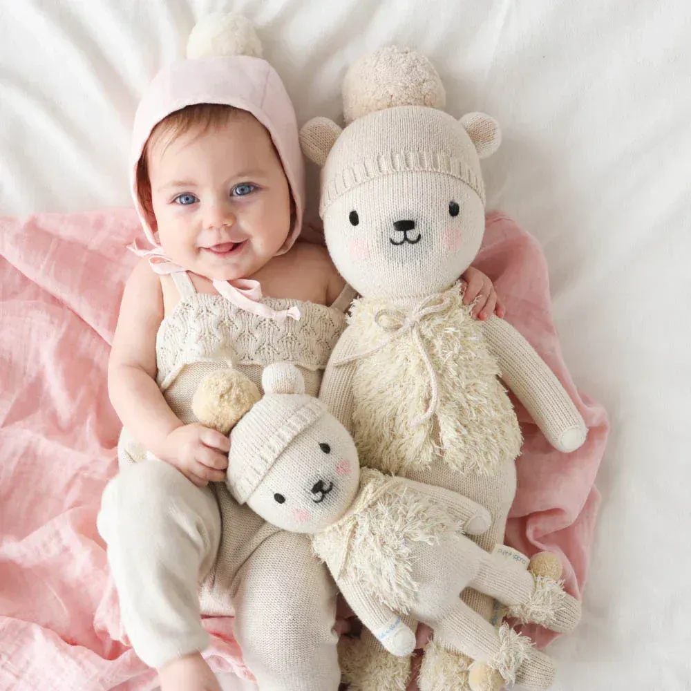 Baby cuddling with knitted teddy bear plush toys