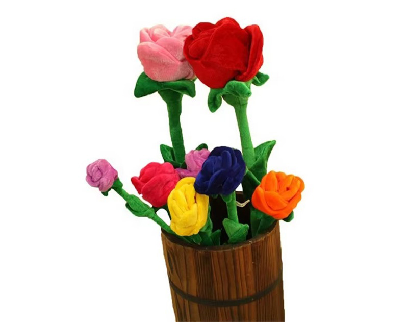 A wooden vase filled with vibrant plush roses in multiple colors—red, pink, yellow, blue, orange, and purple—each with soft green stems and leaves.