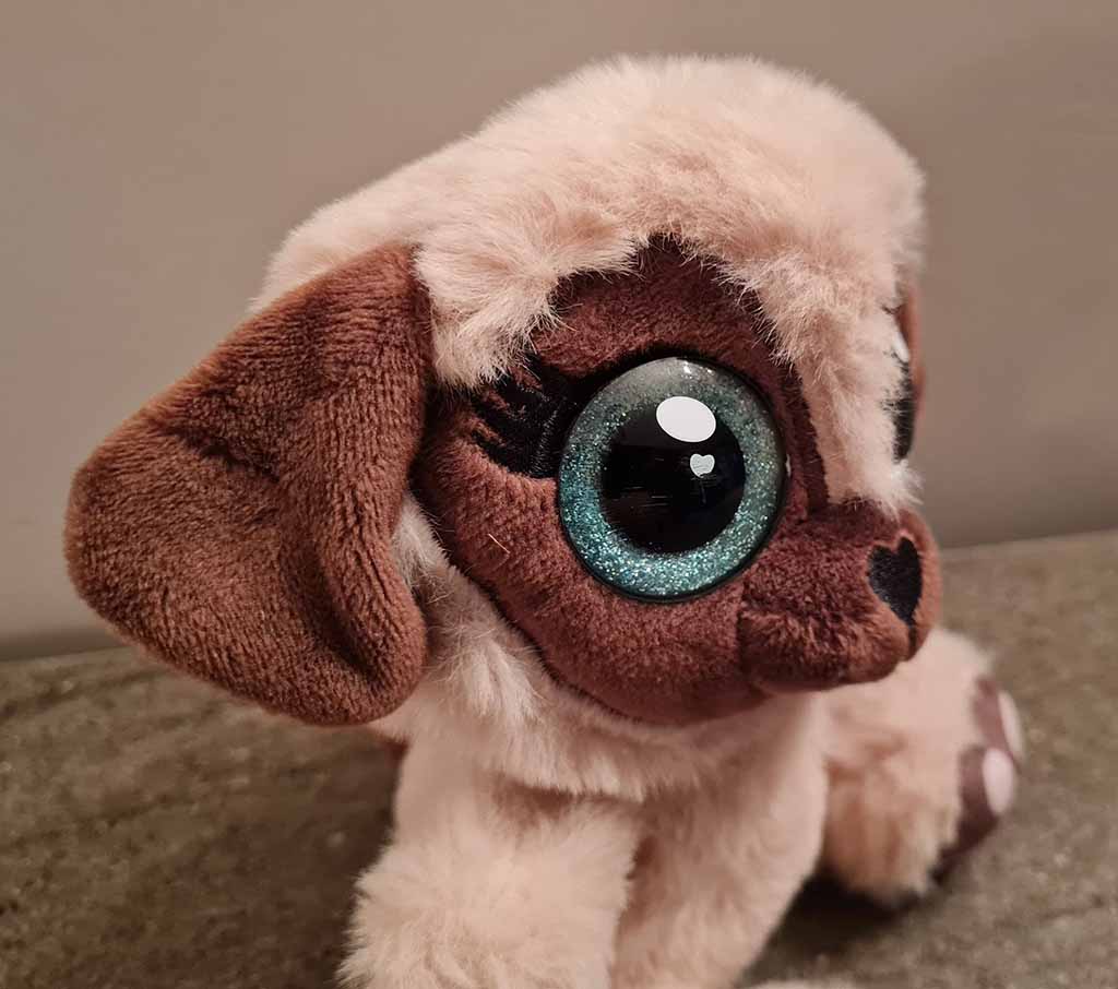 Cute puppy plush toy with oversized glittery eyes and floppy ears.