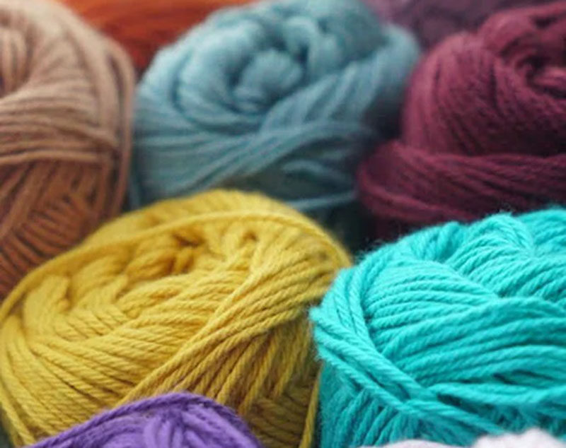 Close-up of colorful yarn balls in multiple shades and textures, showcasing soft fiber materials commonly used for handmade crochet toys, amigurumi dolls, knitted plush products, and artisanal soft toy development, highlighting material quality, color variety, and textile inspiration for custom plush manufacturing and craft-based toy design.