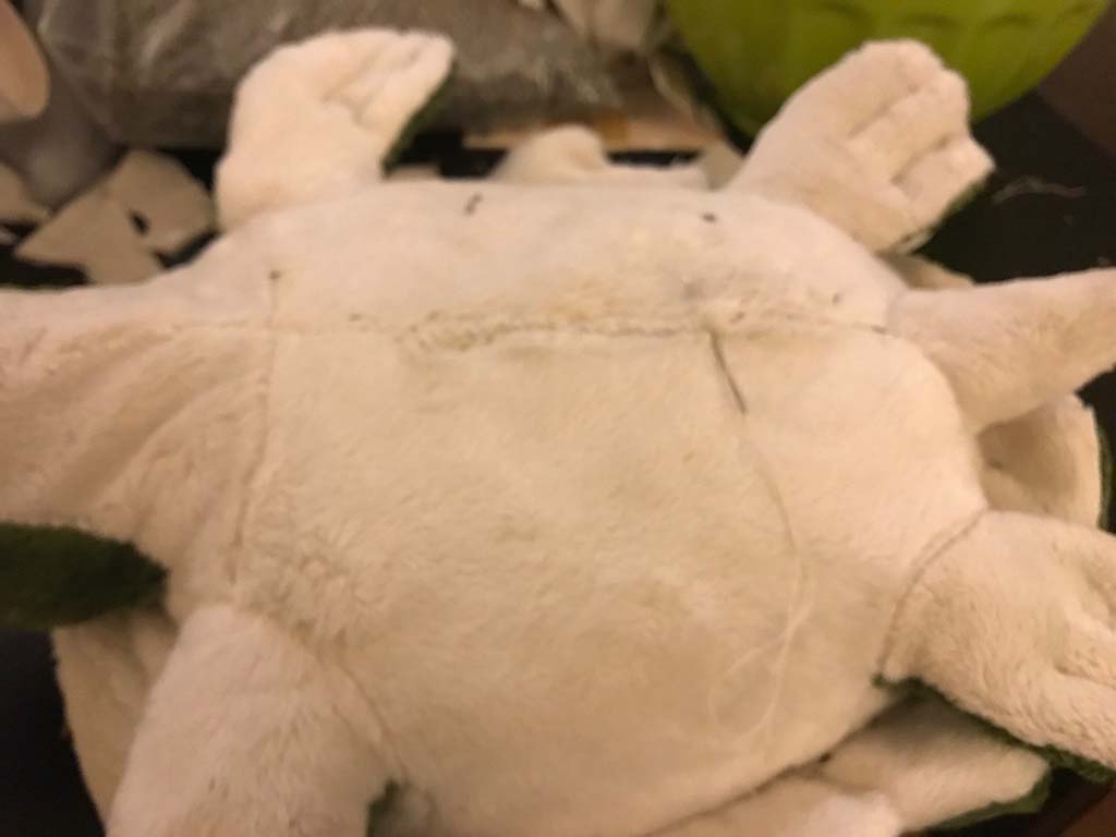 Close-up of a plush toy’s back showing hand-stitched seam closure after stuffing, illustrating finishing and repair techniques used in stuffed animal manufacturing.
