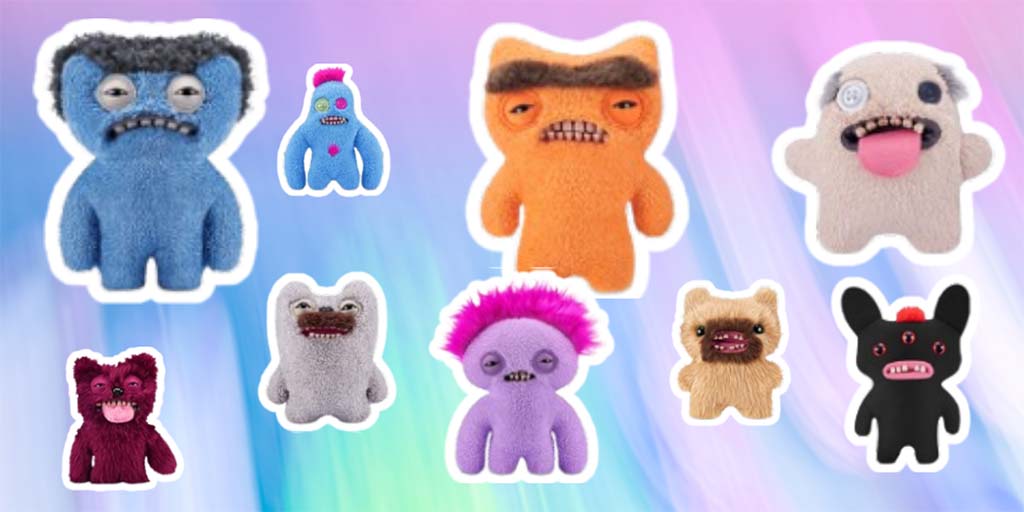A group of colorful Fuggler plush monsters displayed on a pastel background, featuring various quirky designs with mismatched eyes, goofy teeth, fuzzy textures, and humorous facial expressions.