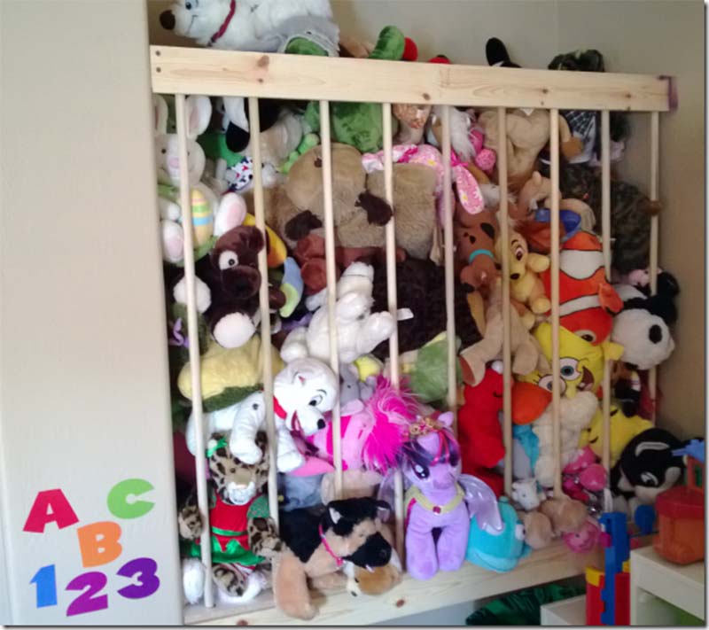 Closet-built stuffed animal zoo made from wooden slats and vertical bars, tightly packed with children’s plush toys and soft animals for organized toy storage.