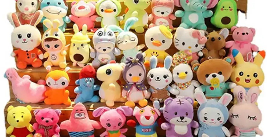 A colorful collection of small plush toys arranged in rows, featuring various animals and cartoon-style characters in bright pastel colors.