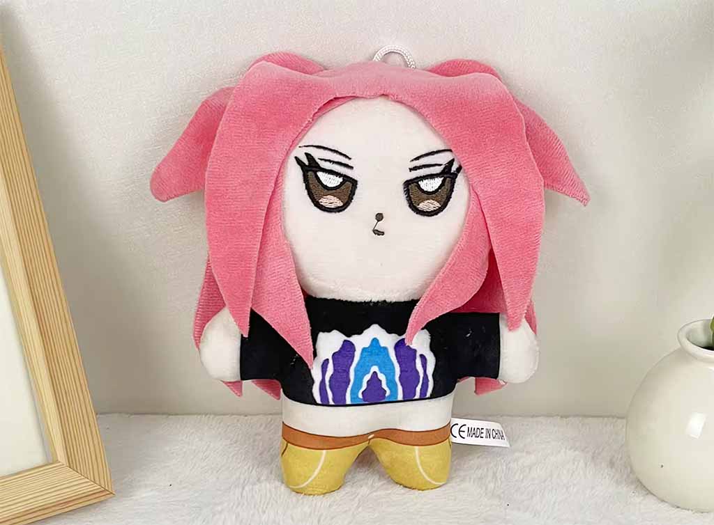 Anime-style plush doll with pink hair and embroidered facial details.
