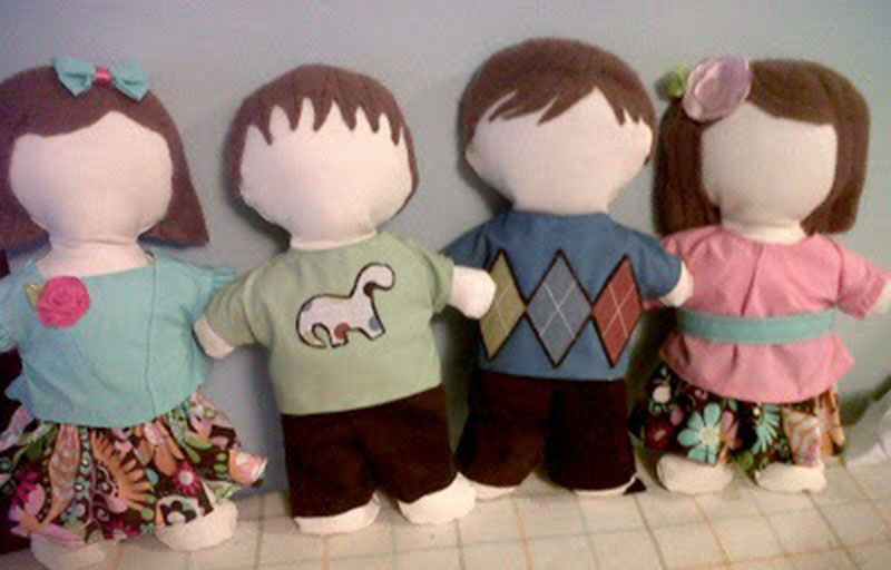 Four handmade ragdoll-style cloth dolls wearing colorful shirts, skirts, and pants, displayed in a row with simple stitched hair and blank faces for a DIY sewing presentation.