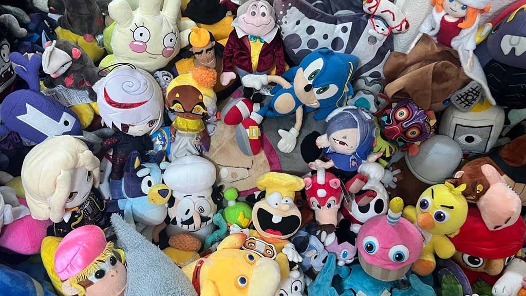Large mixed collection of colorful character plush toys piled together, featuring various animated and video-game inspired figures.
