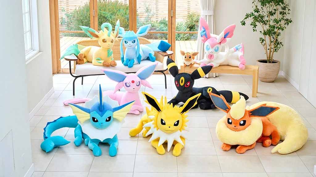 Full set of oversized Eeveelution plush toys, including Vaporeon, Jolteon, Flareon, Espeon, Umbreon, Leafeon, Glaceon, Sylveon, and Eevee, arranged in a bright modern living room.