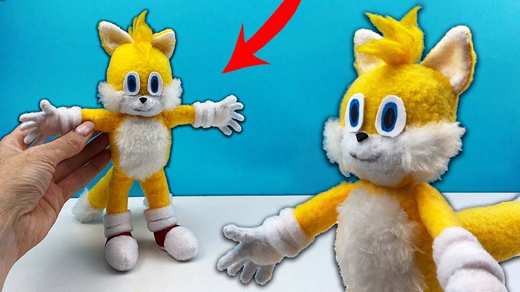 Custom handmade Tails plush toy from Sonic the Hedgehog shown in two angles, featuring yellow fur, white chest and gloves, blue eyes, and fluffy details.