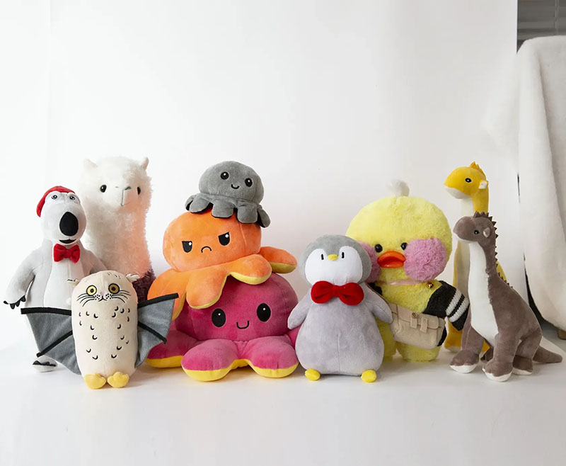Assorted cute animal plush toys arranged in a group on a white background