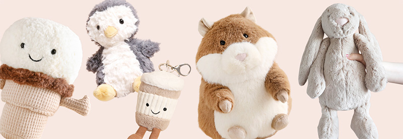 A variety of Jellycat plush toys including animal and food-themed designs, displayed together against a soft pastel background.