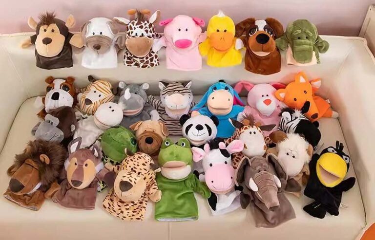 Assorted animal plush hand puppets arranged on a sofa