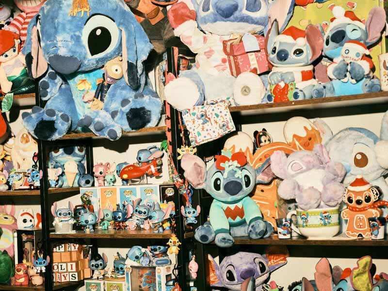 Collection of Stitch plush toys and merchandise displayed on shelves