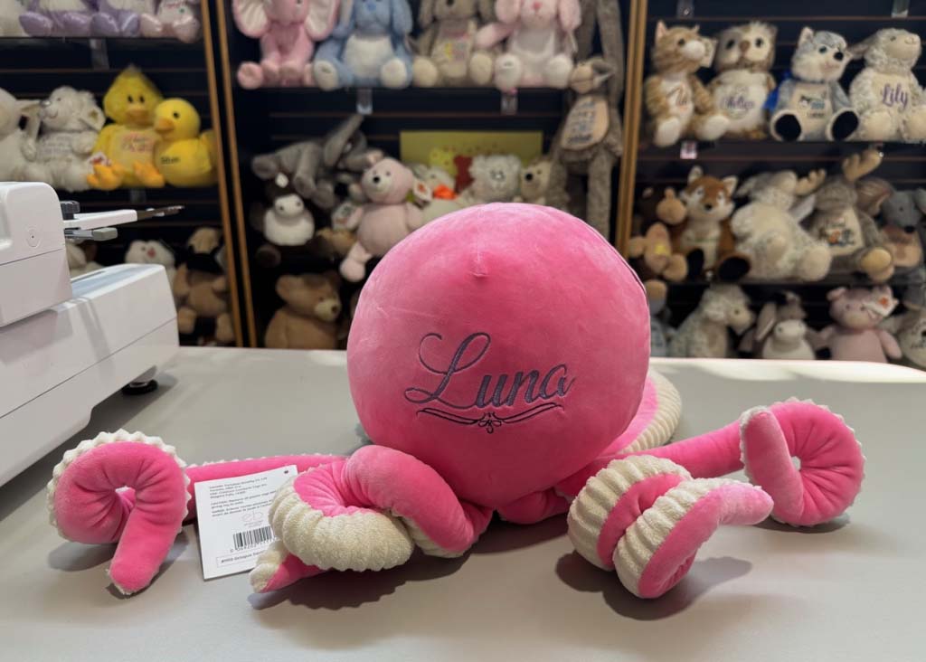 Custom octopus plush toy with embroidered name displayed in plush showroom