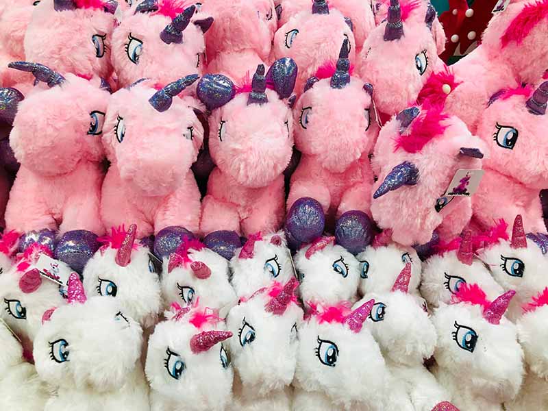 Large group of pink and white unicorn plush toys