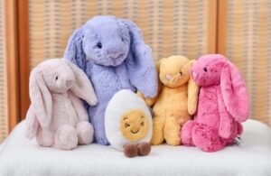 Colorful bunny plush toys arranged together with a small egg-shaped plush